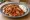 İskender Tavuk: an illustration of chicken, marinara, butter and yogurt on pita.
