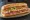 Italian Hero: an illustration of capicola, salami, ham, provolone and more on hoagie roll.