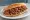 İzmir Kokoreç: an illustration of tomato and oregano on bread.