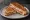 Kanapka z Grilla: an illustration of butter, ham, cheese and tomato on bread.