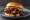 Kansas City BBQ Sandwich: an illustration of beef, pork, pickle and onion on burger bun.