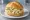 Kartoffelsalat Brötchen: an illustration of potato, mayonnaise, onion, pickle and more on kaiser roll.