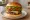 Kasap Burger: an illustration of beef, lettuce, tomato, onion and more on burger bun.