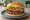 Köfte Burger: an illustration of beef, onion, tomato and lettuce on burger bun.