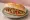 Kokoreç Çeyrek Ekmek: an illustration of tomato, pepper, oregano and cumin on bread.