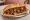 Kokoreç Yağlı: an illustration of tomato, pepper, oregano and cumin on bread.