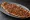 Konya Etli Ekmek: an illustration of beef, lamb, onion, parsley and more on bread.