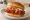 Korean Fried Chicken Sandwich (Global): an illustration of chicken, gochujang, kimchi, radish and more on burger bun.