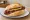 Krakauer: an illustration of sausage, pork, garlic and mustard on kaiser roll.