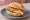 Krustenbraten Brötchen: an illustration of pork and mustard on kaiser roll.