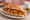 Kuru Fasulye Ekmek: an illustration of beans, tomato and onion on bread.