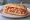Lomi Lomi Salmon Sandwich: an illustration of salmon, tomato and onion on hoagie roll.