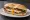 Lomito con Huevo: an illustration of beef, egg, lettuce and tomato on baguette.