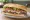 Lomito con Jamón y Queso: an illustration of beef, ham, cheese, lettuce and more on baguette.