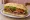 Lomito con Panceta: an illustration of beef, bacon, lettuce and tomato on baguette.