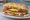 Lomito Especial: an illustration of beef, ham, bacon, cheese and more on baguette.