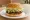 Lotteria — Bulgogi Burger (불고기 버거): an illustration of beef, lettuce, onion, mayonnaise and more on burger bun.