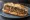 Loukaniko (Λουκάνικο): an illustration of pork, sausage and lemon on bread.