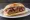 Loukaniko me Portokali: an illustration of pork, sausage and lemon on bread.