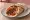 Loukaniko se Pita: an illustration of pork and sausage on pita.