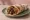 Makanek Sandwich (ساندويش مقانق): an illustration of lamb, sausage, brown sauce and lemon on pita.