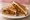 Manchurian Sandwich: an illustration of cabbage, carrot, maggi seasoning sauce, ginger and more on white bread.