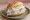Matjes mit Zwiebeln: an illustration of herring, onion and remoulade on kaiser roll.