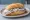 Matjesbrötchen: an illustration of herring, butter and onion on kaiser roll.