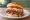 Memphis BBQ Sandwich: an illustration of pork, coleslaw, bbq sauce, tomato and more on burger bun.