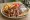 Merida Gyros: an illustration of pork, onion, tomato, tzatziki and more on pita.