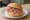 Mettbrötchen ohne Zwiebeln: an illustration of pork and pepper on kaiser roll.