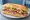Miami Sandwich: an illustration of ham, turkey, bacon, swiss cheese and more on cuban bread.