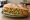 Milanesa con Lechuga y Tomate: an illustration of beef, lettuce and tomato on baguette.