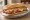 Milanesa Napolitana: an illustration of beef, ham, mozzarella and tomato on baguette.
