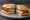 Milanesa Suiza: an illustration of beef, ham, cheese and egg on baguette.