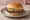 Mississippi Slugburger: an illustration of beef, pork, mustard, pickle and more on burger bun.