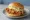 Mom's Touch (맘스터치): an illustration of chicken on burger bun.