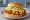 Mom's Touch — Cheese Thigh Burger: an illustration of chicken, cheese and lettuce on burger bun.