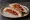 Muhammara Sandwich (ساندويش محمرة): an illustration of pepper, walnuts, brown sauce, olive oil and more on pita.