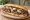 Mushroom Cheesesteak: an illustration of beef, mushroom, cheese and onion on hoagie roll.