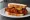 Nashville Hot Chicken Sandwich: an illustration of chicken, cayenne and pickle on white bread.