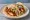 Nashville Hot Chicken Taco: an illustration of chicken, cayenne, pickle and coleslaw on tortilla.