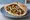 Nazareth Style: an illustration of chickpeas, hummus, tahini, parsley and more on pita.