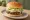 No Brand — NBB Burger: an illustration of beef, lettuce, onion and pickle on burger bun.