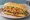 Pan con Bistec: an illustration of onion, tomato, lettuce and potato chips on cuban bread.