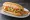 Pan con Minuta: an illustration of lettuce, tomato, garlic and tartar sauce on cuban bread.