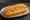 Pancho con Papas Pay: an illustration of sausage and potato chips on hot dog bun.