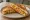 Paneer Bhurji Sandwich: an illustration of onion and tomato on white bread.