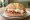 Panino con Burrata e Crudo: an illustration of prosciutto and burrata on kaiser roll.