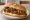 Panino con Caponata: an illustration of eggplant, tomato, caper, olives and more on bread.